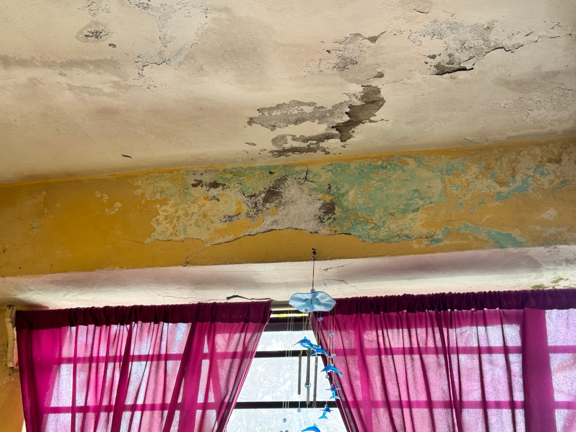 Damp, peeling ceiling and cracked beam above a window · Sikkim